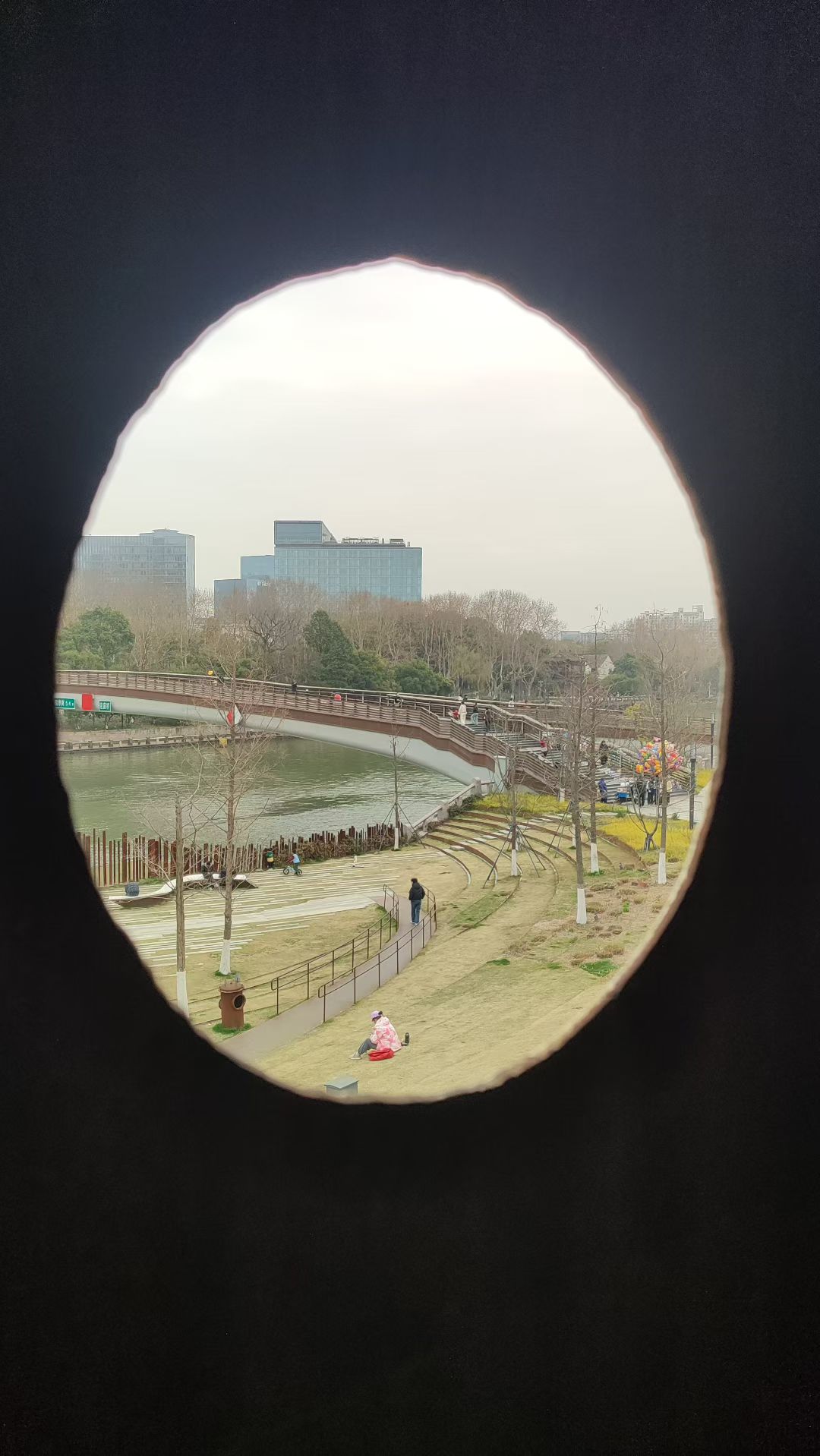 从圆窗看向城市和公园